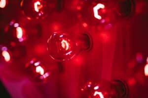 out of focus image of several red light builds vertically installed and emitting red light.