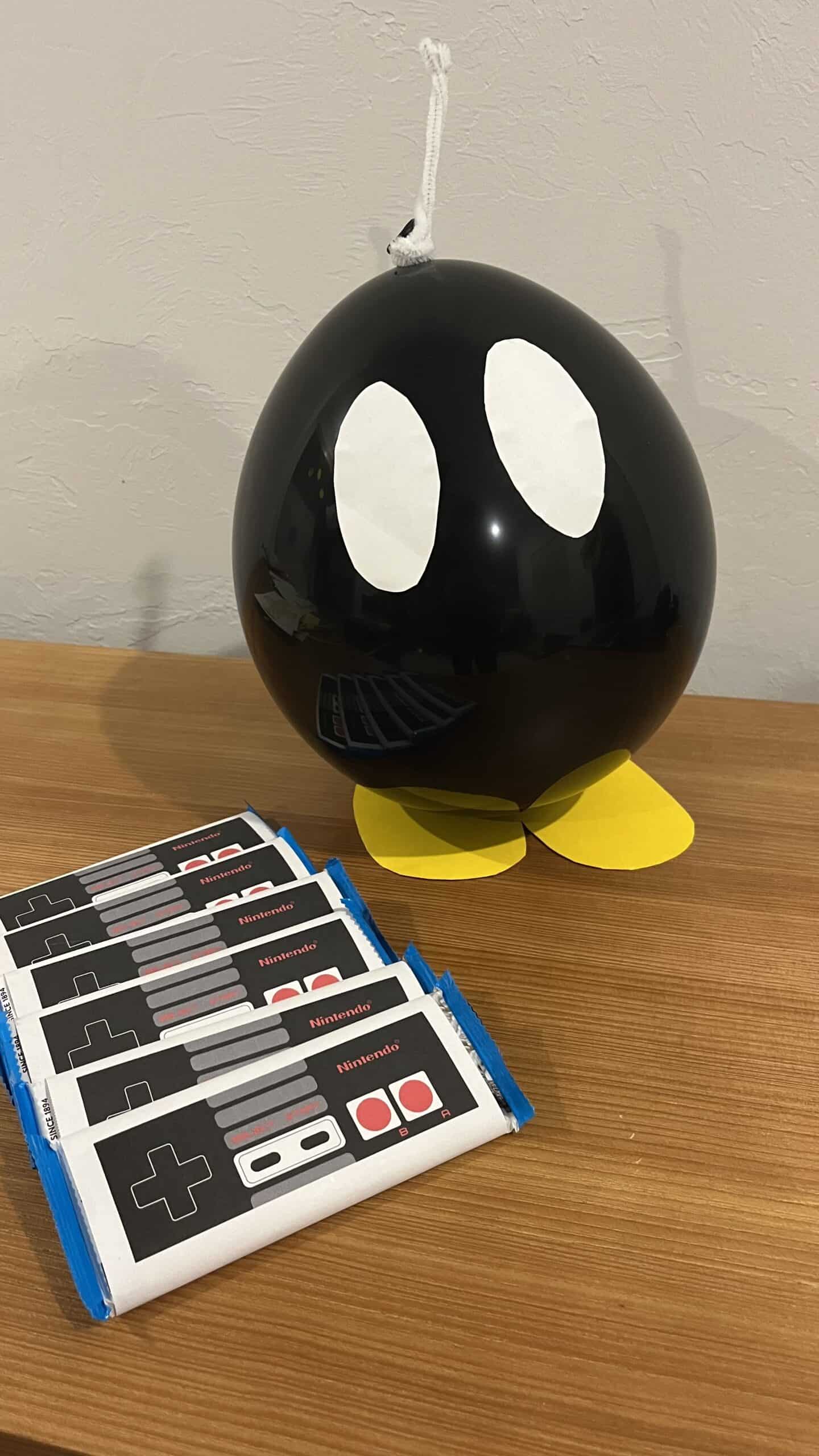 birthday party mario diy bom-omb made out of a balloon and chocolate bars with a nintendo candy bar wrapper