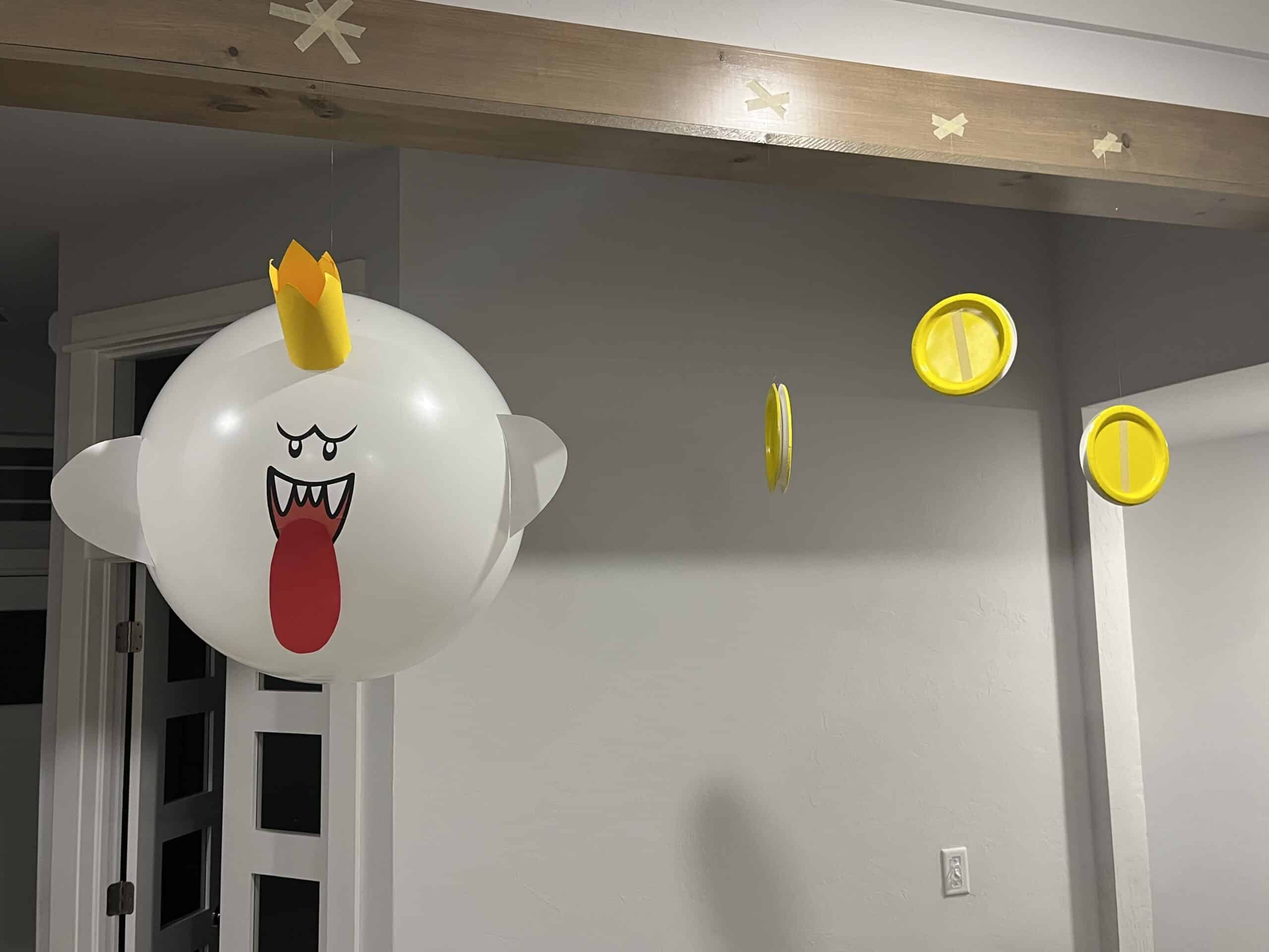 super mario birthday party image of a DIY king boo decoration along with mario coin decoration handing from ceiling