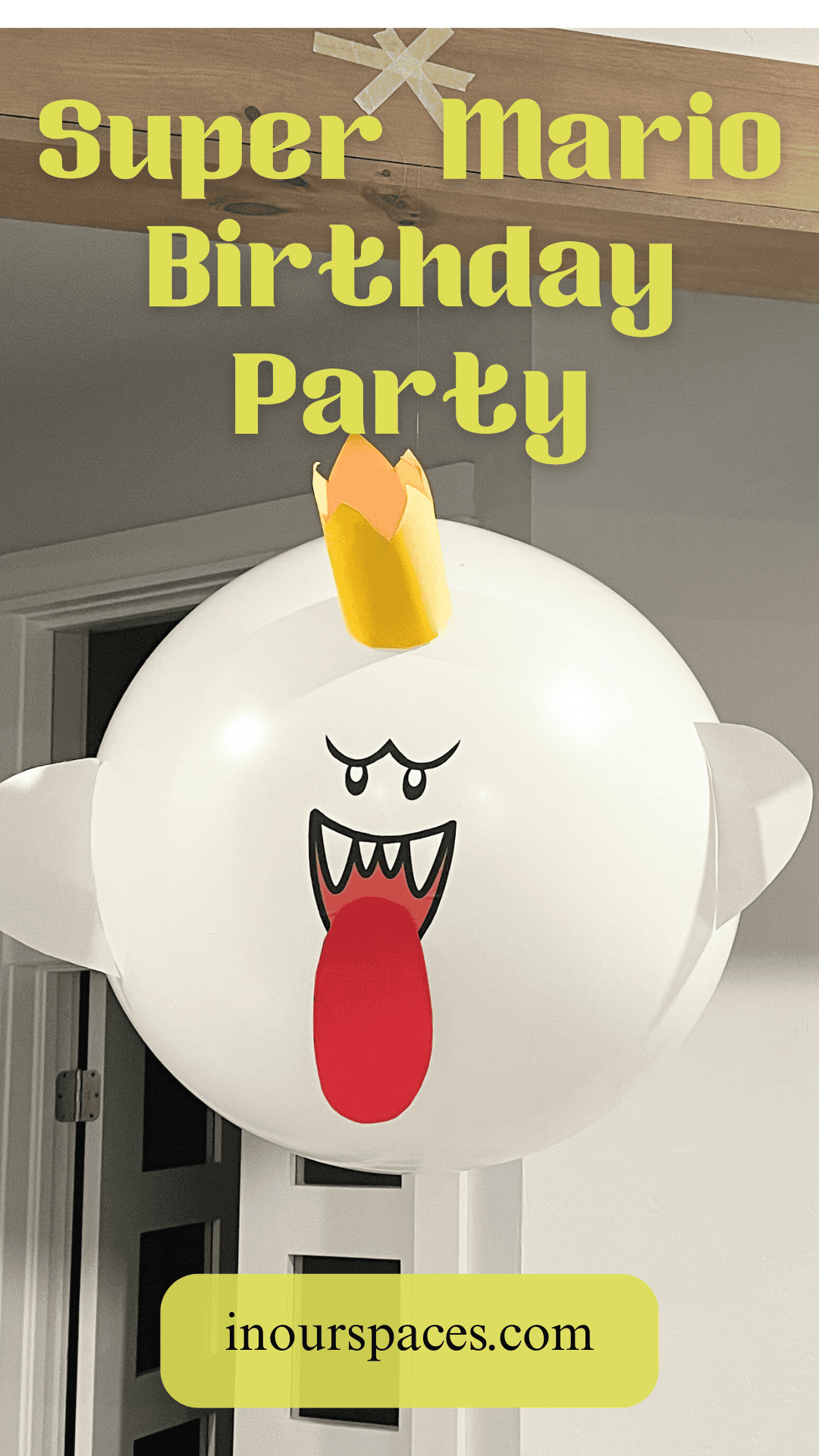 DIY King Boo balloon decoration hanging from ceiling for a Super Mario-themed birthday party with bold yellow text and website inourspaces.com