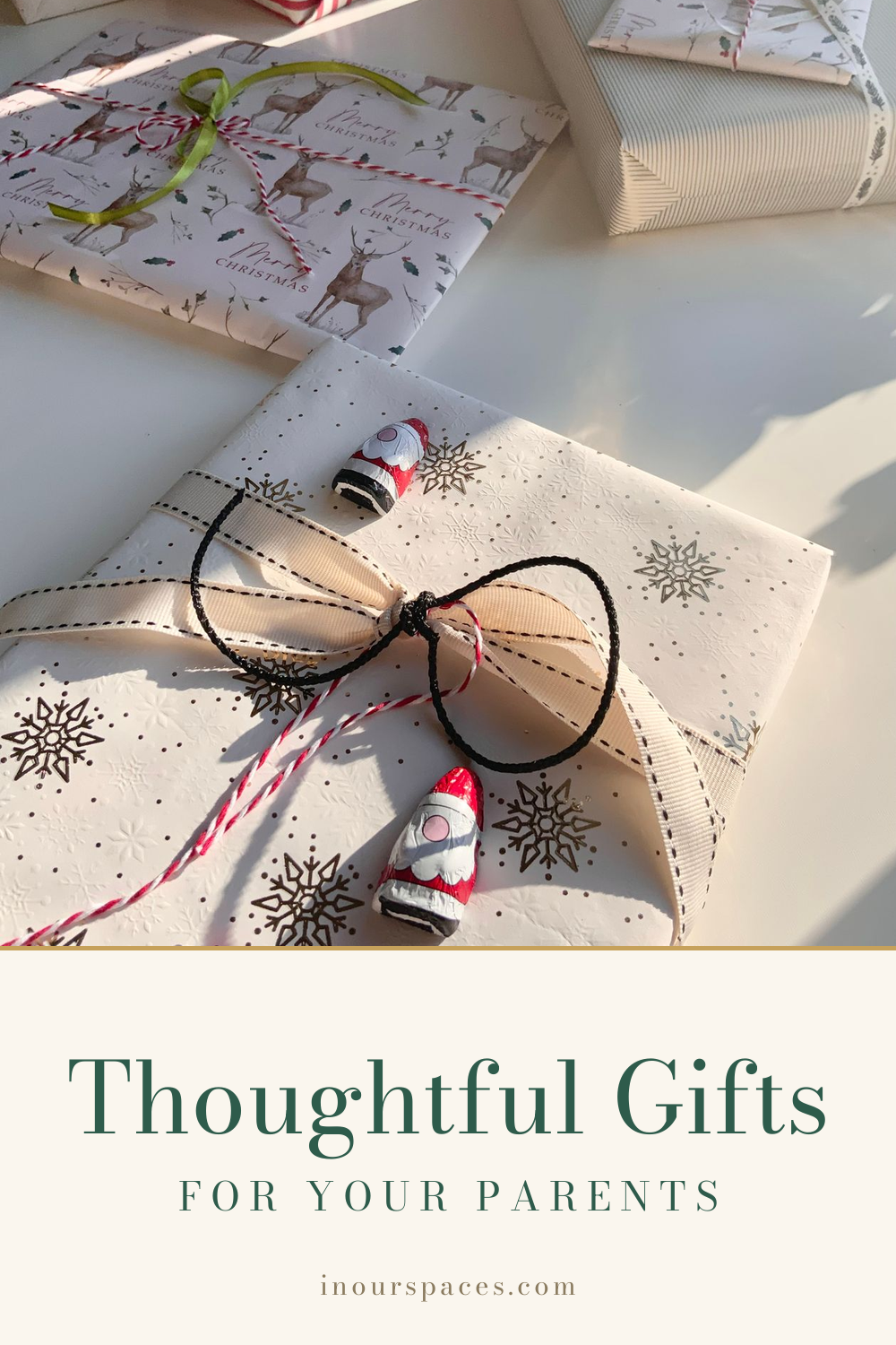 Wrapped Christmas gifts in white paper with reindeer and snowflake patterns and ribbons in bright sunlight, text overlay reading "Thoughtful Gifts for Your Parents" with "inourspaces.com" at the bottom